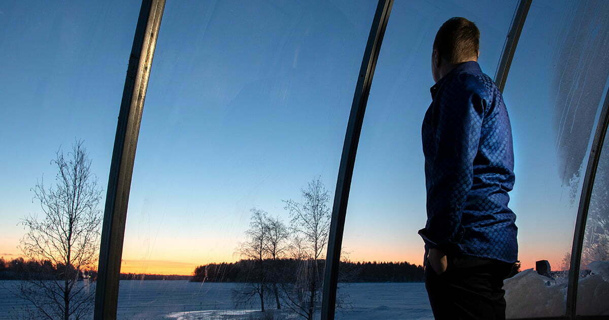 Thomas Åberg njuter av soluppgången på Ice and light village i skjorta Snöflinga