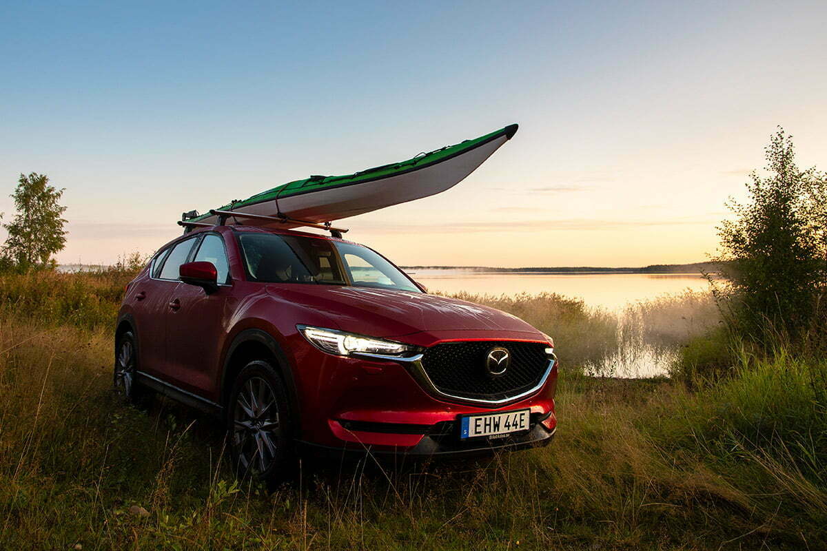 Mazda med kajak och gryning vid en sjö