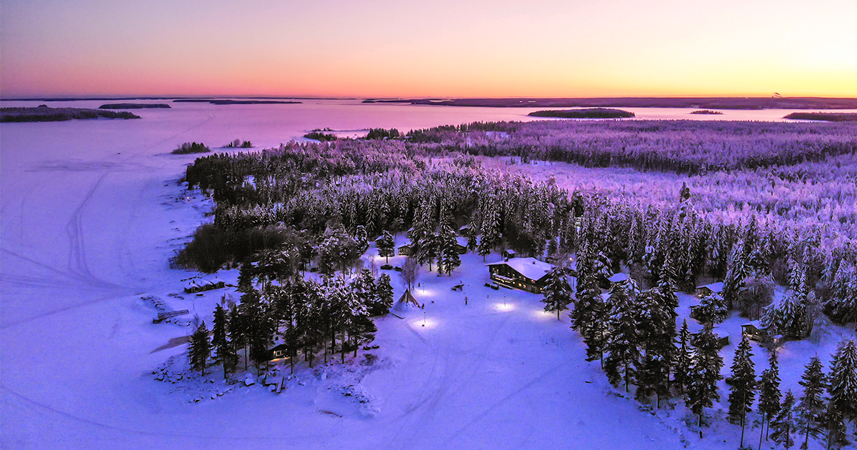 Brändön Lodge drönarbild över vintersolnedgången